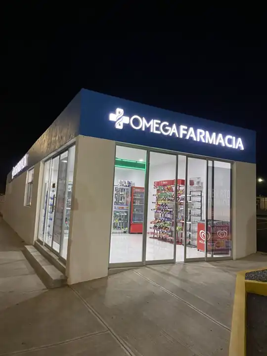 Omega Farmacia de noche con el letrero encendido